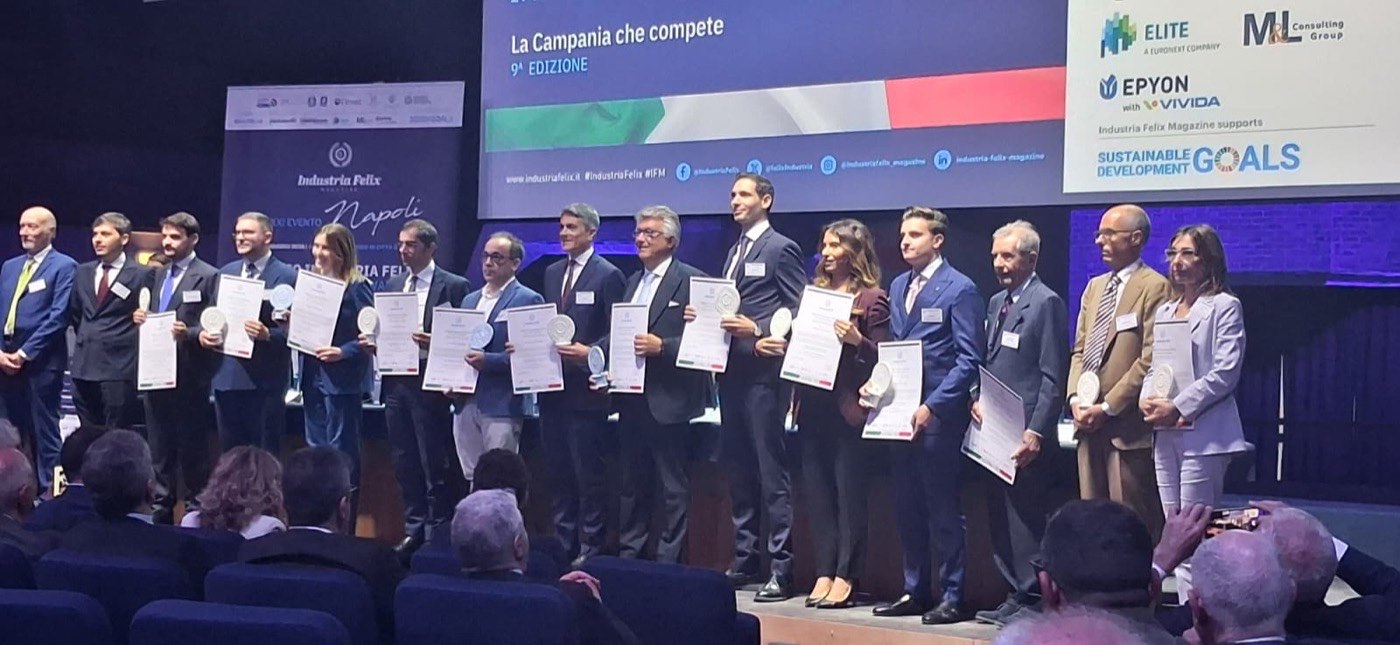 Le imprese premiate sul palco dell'Auditorium di Città della Scienza, ciascuna con la targa e l'attestato in mano; sullo schermo alle loro spalle il titolo dell'evento, «La Campania che compete», nona edizione.